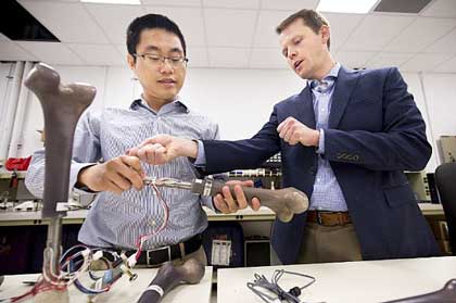 ANN ARBOR, Mich. (Sept. 27, 2017) Dr. Jerome Lynch, right, an engineering professor at the University of Michigan, discusses the results of an experiment with research fellow Wentao Wang. The Office of Naval Research is sponsoring Lynch's work on the Monitoring OsseoIntegrated Prostheses (MOIP), a "smart" artificial leg equipped with specially designed sensors to monitor walking gait, alert users to prosthetic wear and tear and warn of potential infection risk. U.S. Navy photo by Joseph Xu