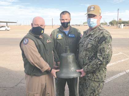 From left to right, NAF El Centro’s “Triad” Cmdr. Jeremy Doughty, Executive Officer, Capt. William Perkins, Commanding Officer, and Master Chief Eric Hubert, Command Master Chief, hold the recovered bell from the USS Dunlap (DD-384) prior to its shipping to the Naval History and Heritage Command. Photo by Kristopher Haugh.