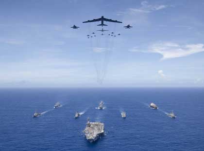 PHILIPPINE SEA (Sept. 17, 2018) The aircraft carrier USS Ronald Reagan (CVN 76) leads a formation of Carrier Strike Group (CSG) 5 ships as U.S. Air Force B-52 Stratofortress aircraft and U.S. Navy F/A-18 Hornets pass overhead for a photo exercise during Valiant Shield 2018. The biennial, U.S. only, field-training exercise focuses on integration of joint training among the U.S. Navy, Air Force and Marine Corps. This is the seventh exercise in the Valiant Shield series that began in 2006. U.S. Navy photo by MC3 Erwin Miciano