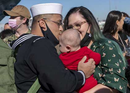 NAVAL BASE SAN DIEGO (Feb. 6, 2022) Cryptologic Technician (Maintenance) 2nd Class Alec McCallister (left), assigned to the Arleigh Burke-class guided missile destroyer USS O'Kane (DDG 77), shares the first kiss with his wife Jade McCallister (right), after returning to their homeport at Naval Base San Diego. O’Kane, a part of the Carl Vinson Carrier Strike Group, returned to Naval Base San Diego, Feb. 6, following an independent deployment to the U.S. 5th and 7th Fleets in support of national tasking and to ensure a free and open Indo-Pacific. U.S. Navy photo by MC3 Stevin C. Atkins.