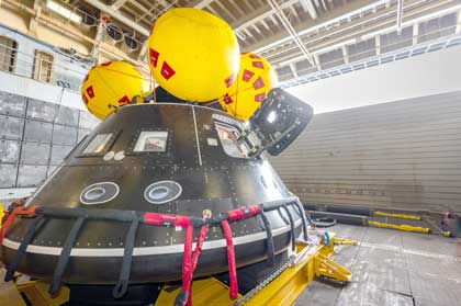 Aboard the USS John P. Murtha, NASA and Department of Defense personnel practice recovery operations for Artemis II in July. A crew module test article is used to help verify the recovery team will be ready to recovery the Artemis II crew and the Orion spacecraft. Credits: NASA/Frank Michaux