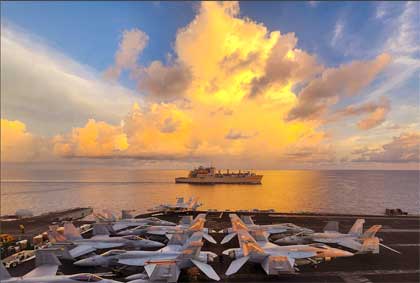 Sunlit Sail: The USNS Wally Schirra and the USS Theodore Roosevelt participate in a replenishment in the South China Sea, May 14, 2024. Photo by Navy Petty Officer 2nd Class Christopher Crawford 