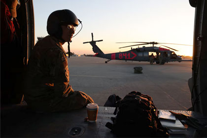 Air Force Airman 1st Class Alessandro Panighetti, an HH-60G Pave Hawk helicopter crew chief with the California Air National Guard, watches the sunrise on the ramp at Los Alamitos Army Airfield on Joint Forces Training Base, Los Alamitos, Calif., before traveling with the aircrew on a repositioning flight to a CAL FIRE helitack base, Jan. 11, 2025. Photo by Air Force Staff Sgt. Crystal Housman